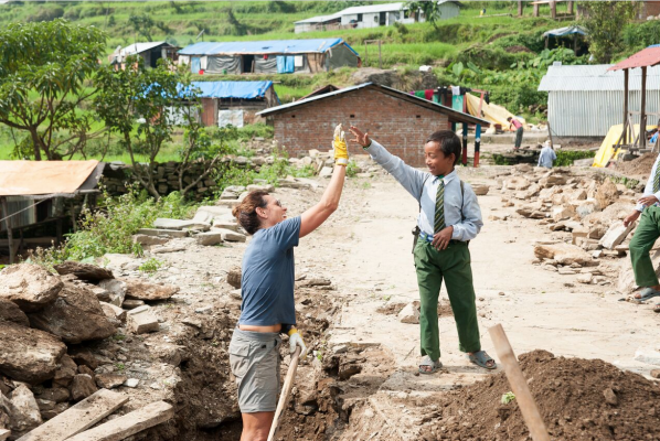 Frau gibt Kind High Five in Nepal