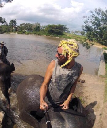 Zwei Männer reiten auf zwei Elefanten durchs Wasser
