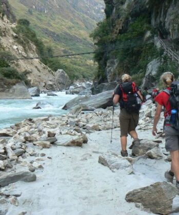 Wanderer neben einem Fluss im Annapurnagebirge