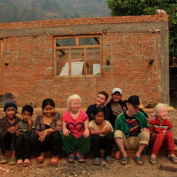 Kinder sitzen vor Baustelle in Swaragau
