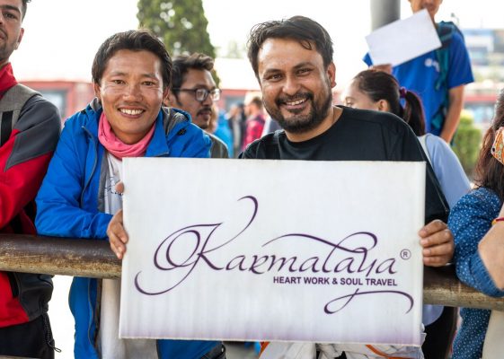 Bhagwan und Guide Jagat halten ein Karmalaya-Schild auf der Leadership-Journey