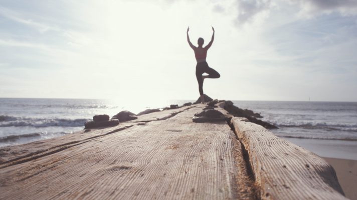 Mann beim Yoga auf einem Steg