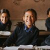 Lächelnde Schulmädchen sitzen im Klassenzimmer in Indonesien