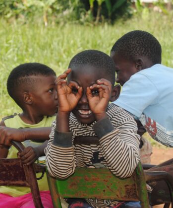 Kind aus Uganda formt Brille mit Händen