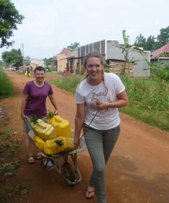 Freiwillige transportieren Wasserkanister in Uganda
