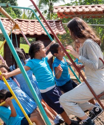 Volontärin schaukelt mit Kindern